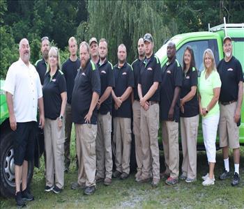 Photo of Employees in front of decaled SERVPRO Service Van