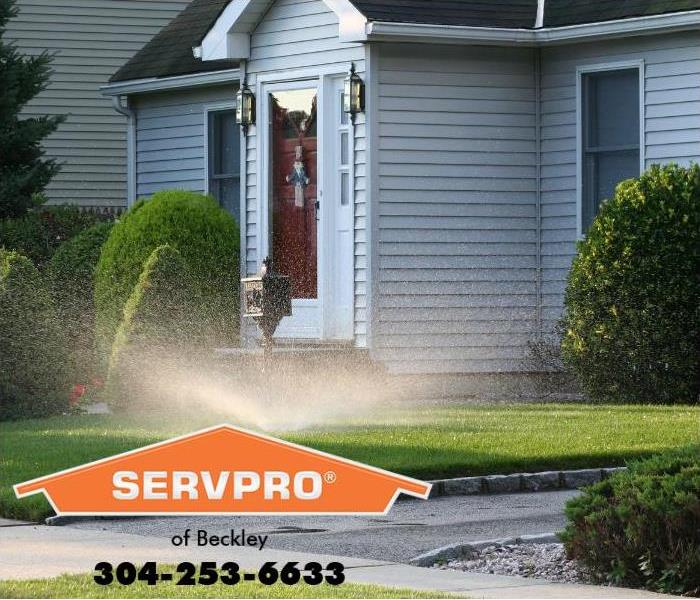 A sprinkler is shown running outside a home. 