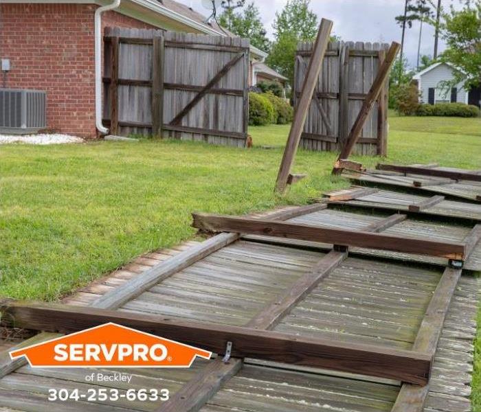 A backyard fence has blown over during a storm.
