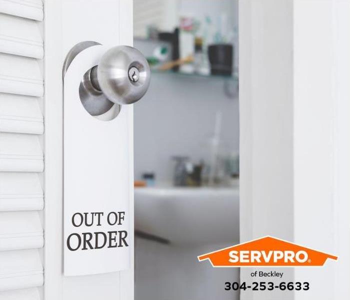 A bathroom door has an “out of order” sign on the door handle.